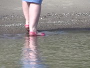 On high heels and bare feet on the sand, plump legs walk along the shore.