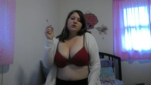Busty girl smokes and gives a peak