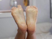Wrinkled soles with cute toes covered in lotion