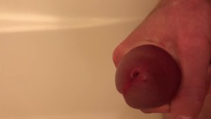 Guy pisses in the tub, then jerks himself off until he cums