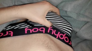 Twink plays with dick through briefs in bed