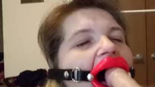 Trying to talk while giving a blowjob to Dildo, wearing open mouth gag