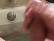 Stroking cock and hairy balls in bathtub with baby oil.