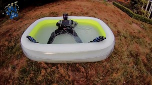 Rufus pawing off in wetsuit, fins and pool