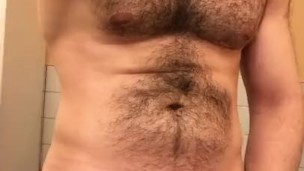 Muscled hung hairy stud jerking in public restroom