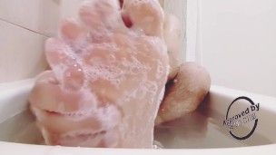 Foot massaging in the bath all wet and soapy