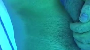 Fit man jerks off in tanning bed