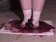 Plump legs in white socks mercilessly trample grapes. Crush fetish