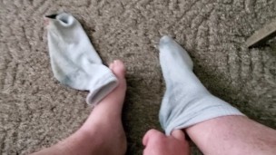 Takes sweaty, dirty work socks off and shows feet!