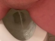 Teen takes a close-up piss and sucks cock on the toilet