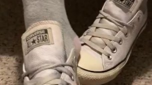 Ebony teen taking off sweaty shoes after class