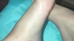 Rubbing lotion on feet and showing off soles 