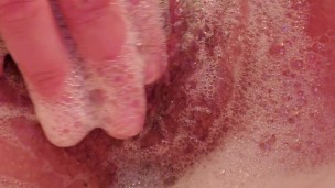 Soapy, wet pussy being played with in a bubble bath. 
