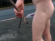 Naked with and without penis pump at side of busy road
