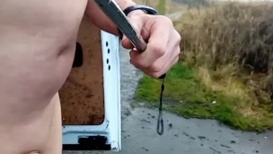 Naked with penis pump on walking at side of busy road