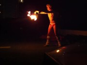 Blond guy spins fire on rooftop in socks and underwear 15/16