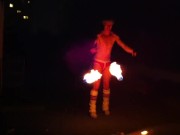 Blond guy spins fire on rooftop in socks and underwear 3/16