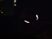 Blond guy spins fire on rooftop in socks and underwear 9/16