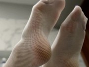 Legs in white fishnet stockings plays with soap bubbles