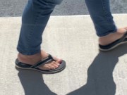 Female friend feet in flip flops coming to see me in public, in motion view