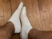 Étudiant joue avec ses pieds en chaussettes blanches