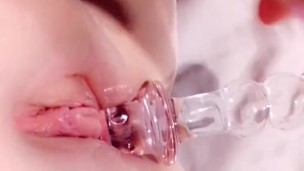 Pink glass dildo sliding in and out of wet pussy