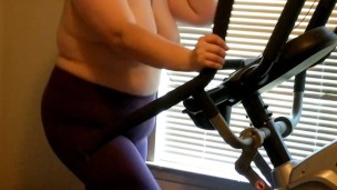 Wife exercising on elliptical topless 