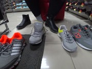 Foot fetish in a public shoe store. Fat legs try on sneakers. 1/16