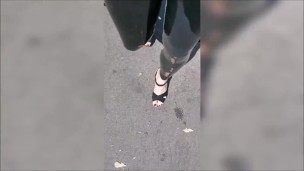 Girl wearing latex leggings and high heels in public