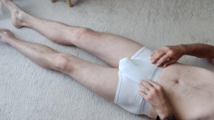 naked guy locked in chastity is caressing his cock.