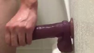 Riding dildo on wall of shower 