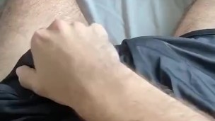 Stroking through shorts before revealing cock