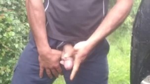 Hauls out cock and balls, pisses on the ground, in rubber boots and uniform