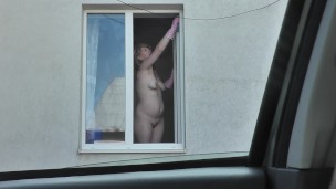 Outside Naked woman on street. Taxi driver saw naked woman washing window apartment. Naked public