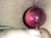 Slowly inserting anal beads and pulling them out