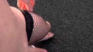 Daylight nude in fishnets and ball weights on path . People about