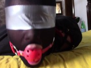 Laura is wearing panthyhose and high heels. She's hogtied, masked, blindfolded and ballgagged