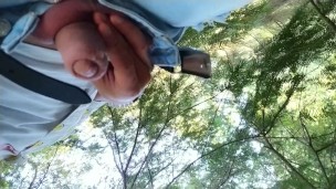 Peeing in the park behind a tree