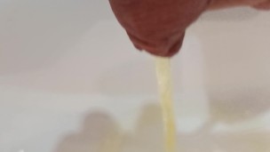 Secretly peeing into the sink with yellow urine.