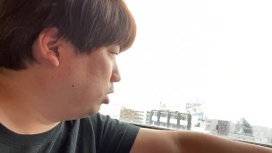 日暮里でホテルから見える景色を説明する男