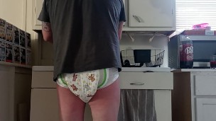 Baby wets diaper while washing dishes