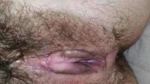 masturbating her hairy pussy while sitting on the couch before work