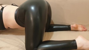 Gata sexy brincando em couro brilhante se tocando