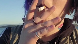 Alternative girl smoking cigarettes on the beach