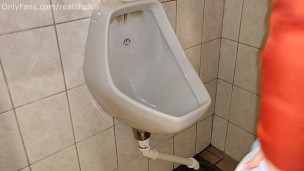 Gril peeing in the urinal