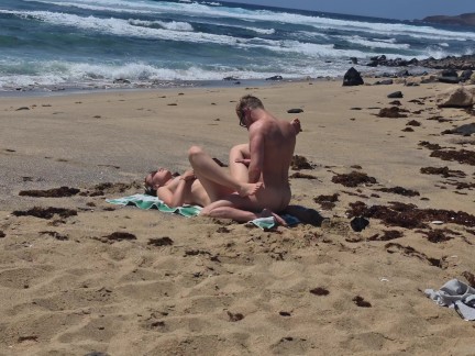Fille qui bronze seins nus se fait baiser à la plage sur le sable, Naemyia