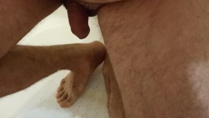 Guy pissing in the bathroom. Парень ссыт в ванной и попадает мочей на ноги. 