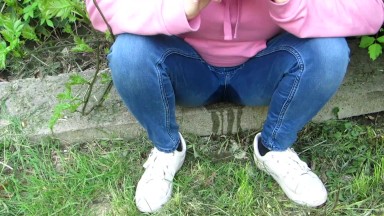 Pissing jeans in public street in sunny day