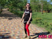 A BEAUTIFUL GIRL IN GLASSES WALKS IN A PARK IN A SHORT SKIRT ATTRACTING THE ATTENTION OF OTHER PEOPL 3/16