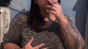 Latina Tatuada Fumando mientras muestra las Tetas